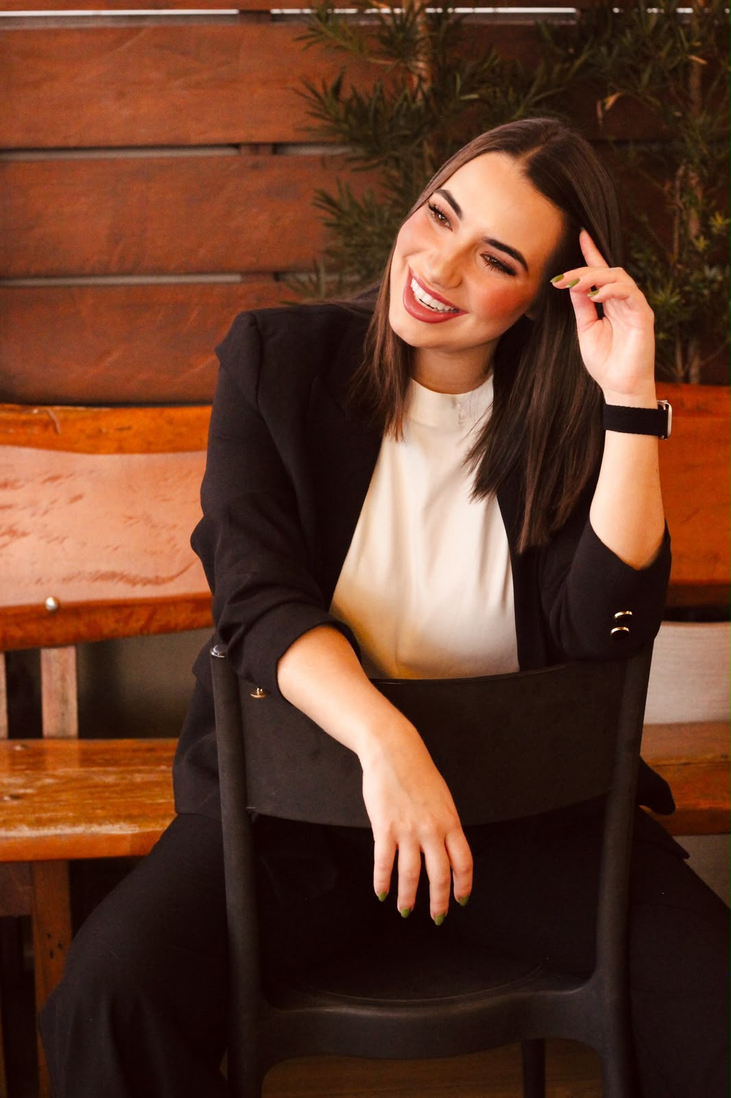Pâmela Domiciano sorrindo, sentada em uma cadeira.